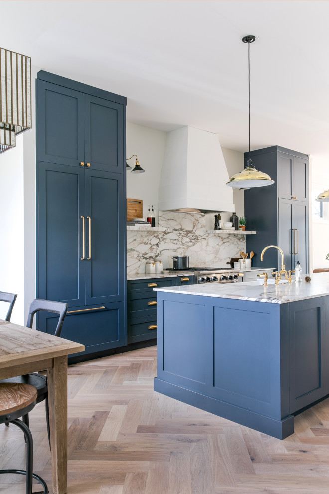 Medium sized classic galley open plan kitchen in Calgary with a double-bowl sink, shaker cabinets, blue cabinets, marble worktops, multi-coloured splashback, marble splashback, integrated appliances, light hardwood flooring, an island and multicoloured worktops.