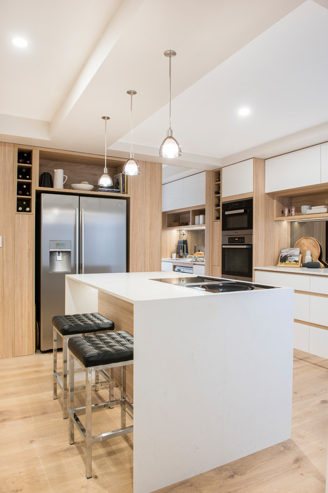 Mittelgroße Moderne Küche mit weißen Schränken, Quarzwerkstein-Arbeitsplatte, Rückwand-Fenster, Küchengeräten aus Edelstahl, hellem Holzboden und Kücheninsel in Perth