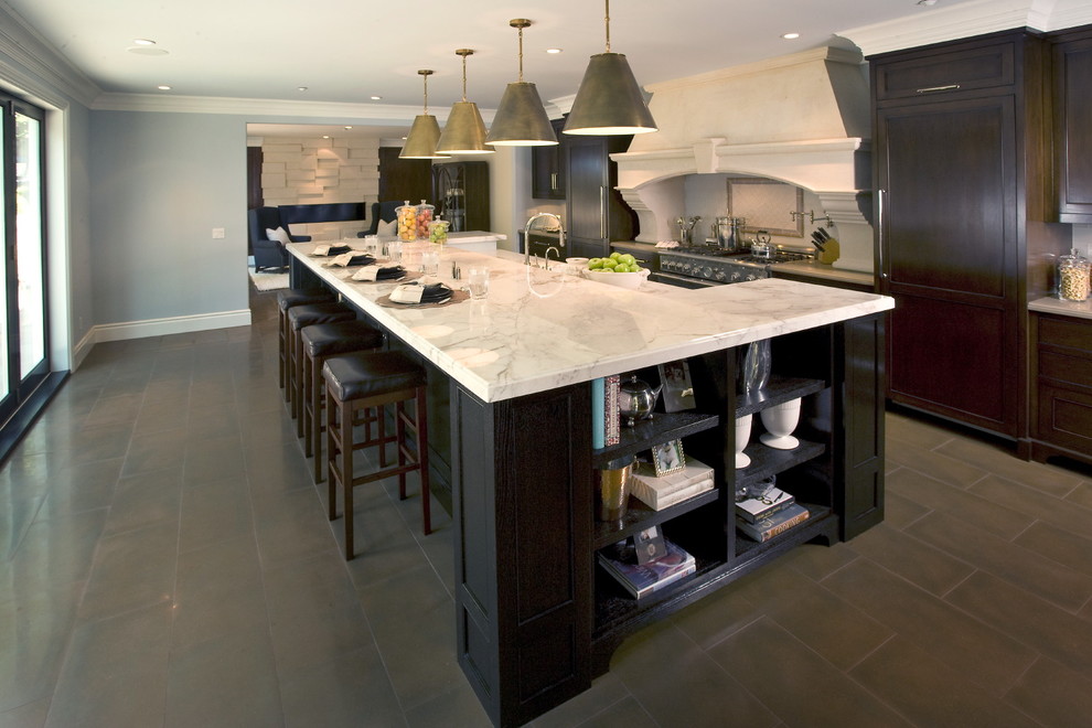 Diseño de cocina clásica con armarios con paneles empotrados, puertas de armario de madera en tonos medios, electrodomésticos con paneles y encimera de mármol