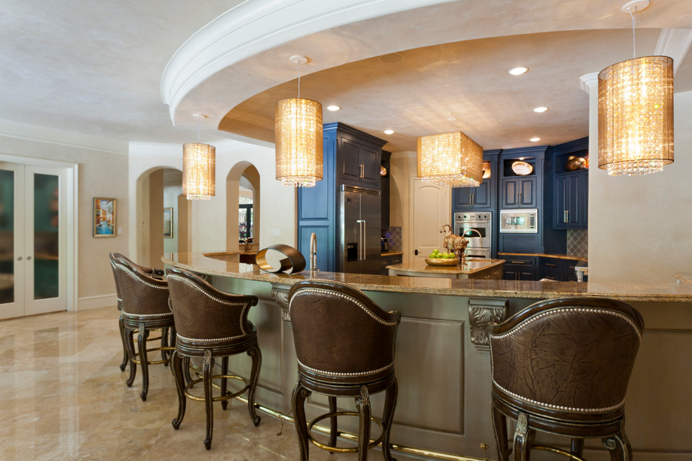 Idée de décoration pour une grande cuisine ouverte tradition en U avec des portes de placard bleues et îlot.
