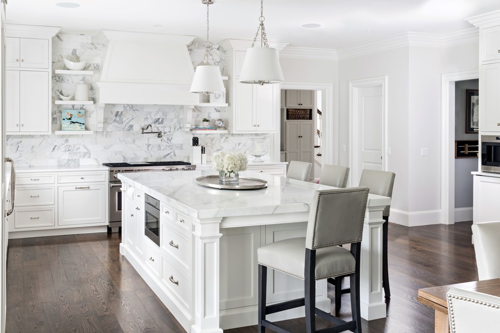 Inspiration for a traditional kitchen/diner in Boston with shaker cabinets, white cabinets, multi-coloured splashback, stainless steel appliances, dark hardwood flooring, an island, brown floors and white worktops.