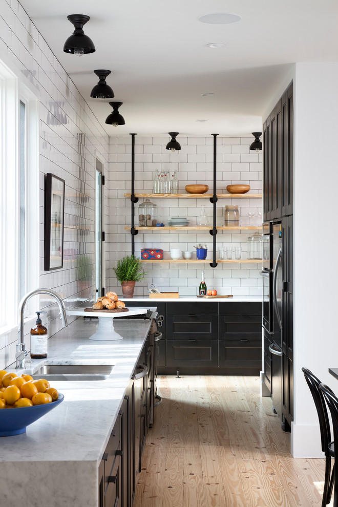 Danish light wood floor eat-in kitchen photo in Austin with no island, an undermount sink, shaker cabinets, marble countertops, white backsplash, subway tile backsplash and stainless steel appliances