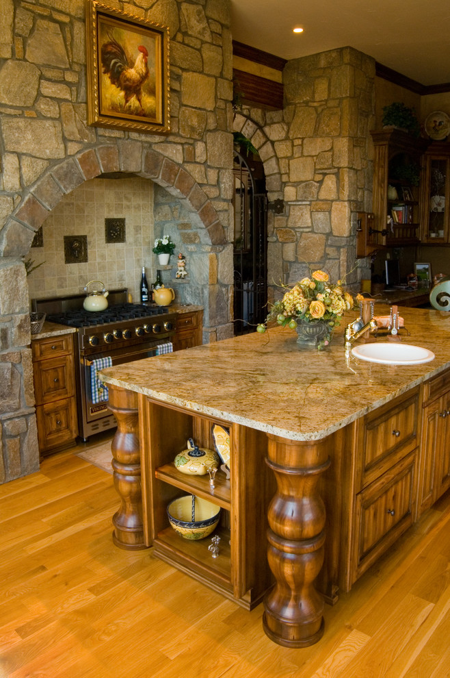 Foto di una grande cucina stile rurale con ante con bugna sagomata, ante in legno scuro, top in granito e elettrodomestici in acciaio inossidabile