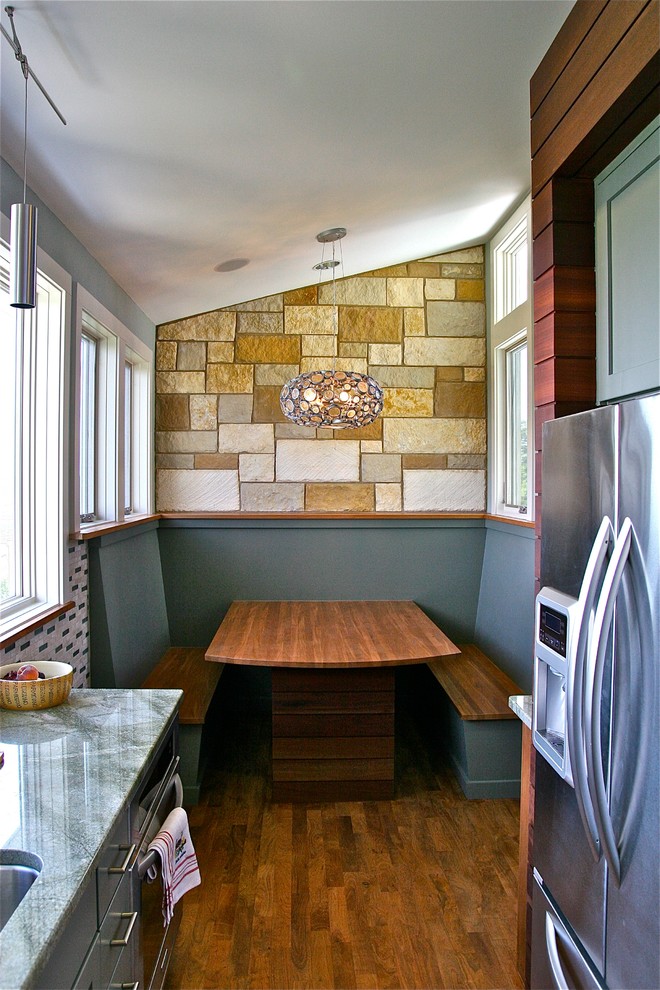 Mittelgroße Moderne Wohnküche in U-Form mit Unterbauwaschbecken, Schrankfronten im Shaker-Stil, grauen Schränken, Küchengeräten aus Edelstahl, Granit-Arbeitsplatte, bunter Rückwand, Rückwand aus Glasfliesen und braunem Holzboden in Austin