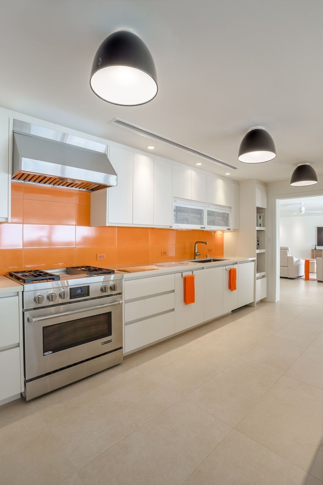 Design ideas for a medium sized contemporary single-wall enclosed kitchen in Hawaii with a submerged sink, flat-panel cabinets, white cabinets, engineered stone countertops, orange splashback, porcelain splashback, stainless steel appliances, porcelain flooring, no island and beige floors.