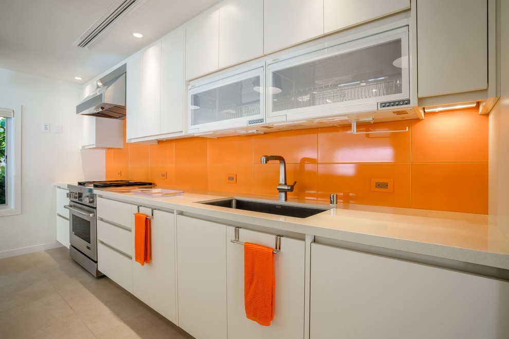 This is an example of a medium sized contemporary single-wall enclosed kitchen in Hawaii with a submerged sink, flat-panel cabinets, white cabinets, engineered stone countertops, orange splashback, porcelain splashback, stainless steel appliances, porcelain flooring, no island and beige floors.
