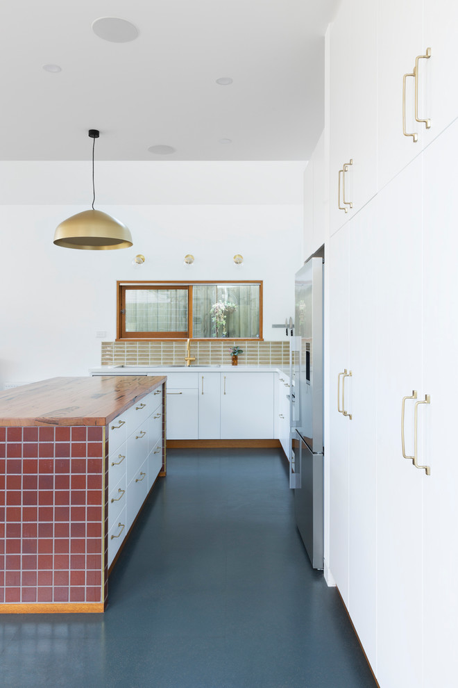 Inspiration for a contemporary open plan kitchen in Melbourne with white cabinets, wood worktops, brown splashback, ceramic splashback, stainless steel appliances, lino flooring, an island and turquoise floors.