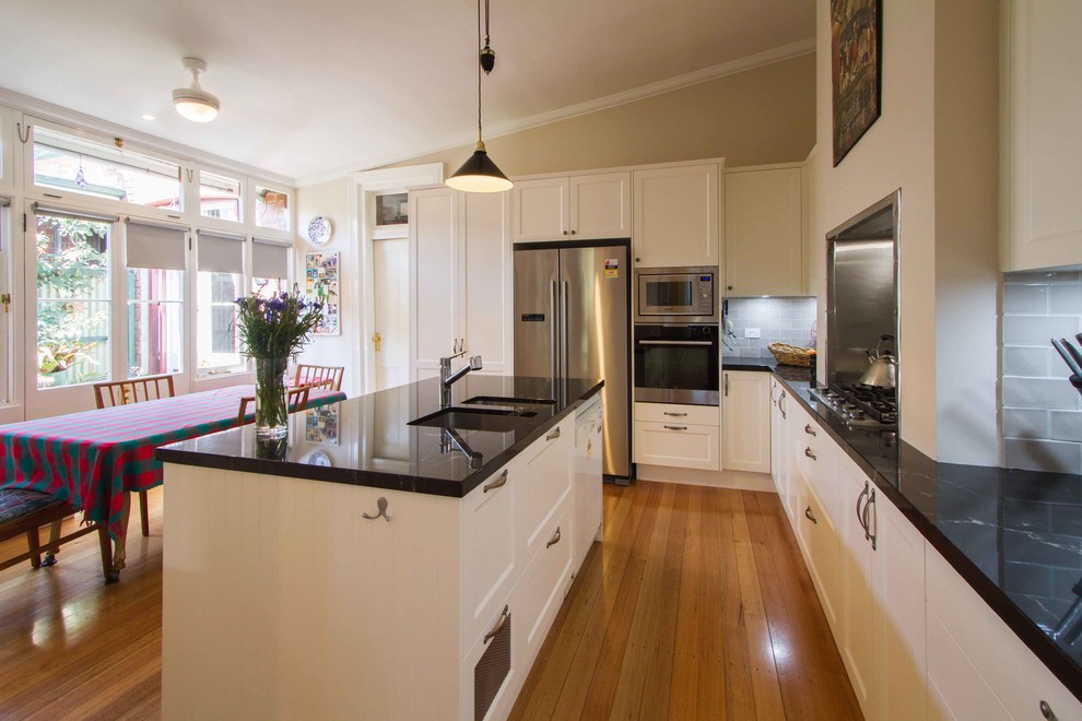 Mittelgroße Klassische Wohnküche in L-Form mit Schrankfronten im Shaker-Stil, Granit-Arbeitsplatte, Küchenrückwand in Grau und Kücheninsel in Melbourne