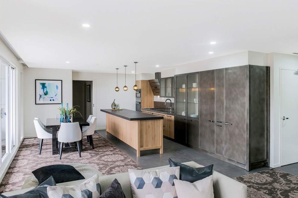 Contemporary galley kitchen/diner in Melbourne with an integrated sink, raised-panel cabinets, medium wood cabinets, stainless steel worktops, metallic splashback, stainless steel appliances, ceramic flooring and multiple islands.