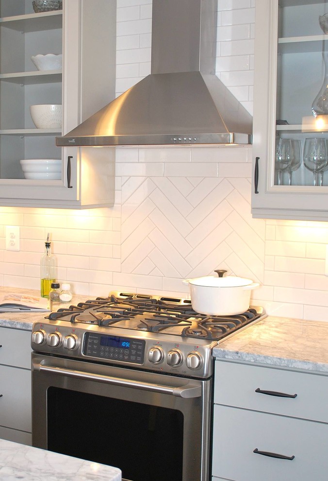 Inspiration for a mid-sized transitional u-shaped dark wood floor eat-in kitchen remodel in DC Metro with a farmhouse sink, recessed-panel cabinets, gray cabinets, quartzite countertops, white backsplash, porcelain backsplash, stainless steel appliances and an island
