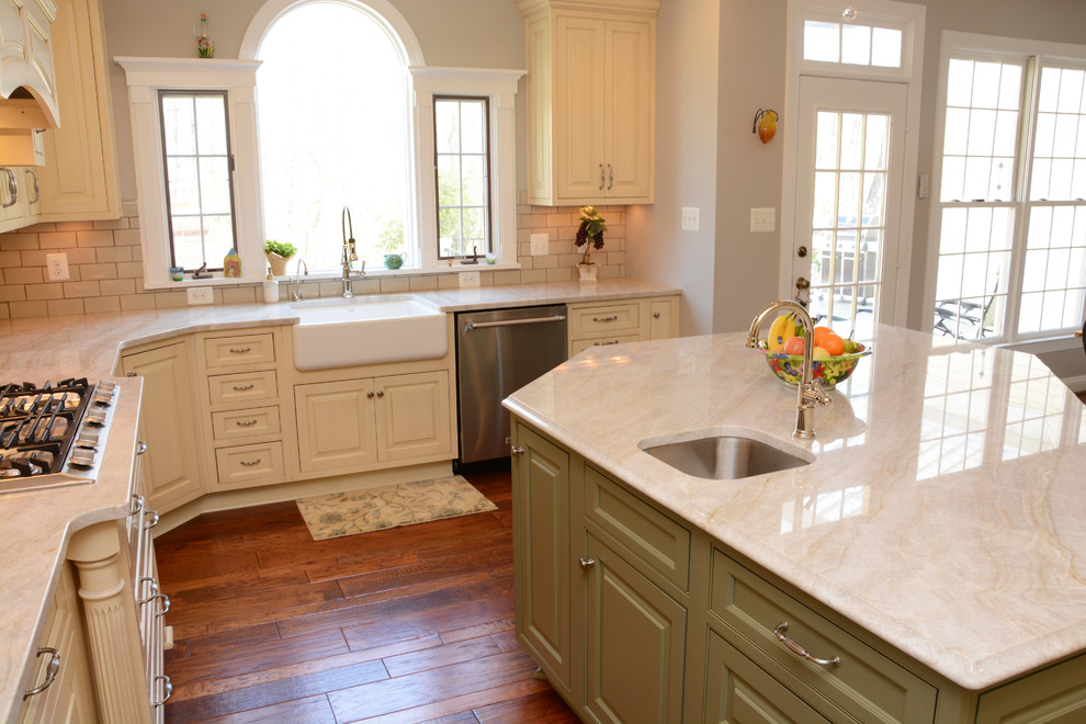 Inspiration for a large transitional l-shaped dark wood floor open concept kitchen remodel in DC Metro with a farmhouse sink, raised-panel cabinets, yellow cabinets, quartzite countertops, beige backsplash, stainless steel appliances and an island