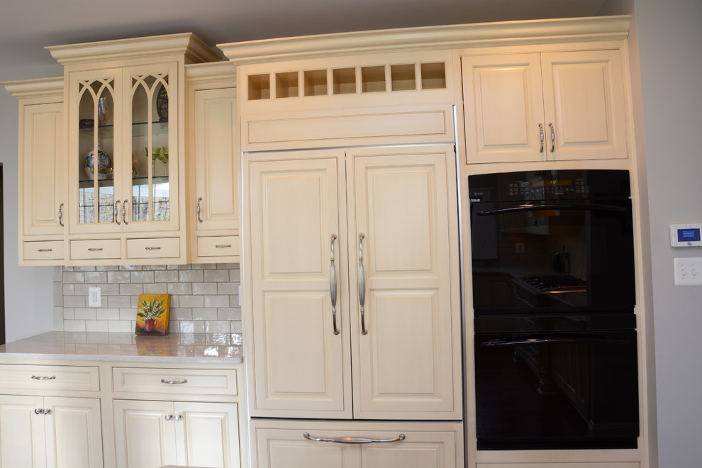 Exempel på ett stort klassiskt kök, med en rustik diskho, luckor med upphöjd panel, gula skåp, bänkskiva i kvartsit, beige stänkskydd, rostfria vitvaror, mörkt trägolv och en köksö