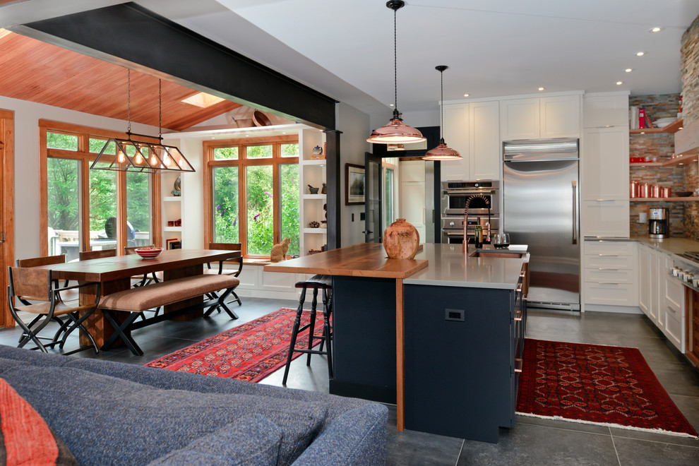 Eklektisk inredning av ett mellanstort kök, med en rustik diskho, skåp i shakerstil, svarta skåp, träbänkskiva, flerfärgad stänkskydd, stänkskydd i stenkakel, rostfria vitvaror, klinkergolv i porslin, en köksö och grönt golv