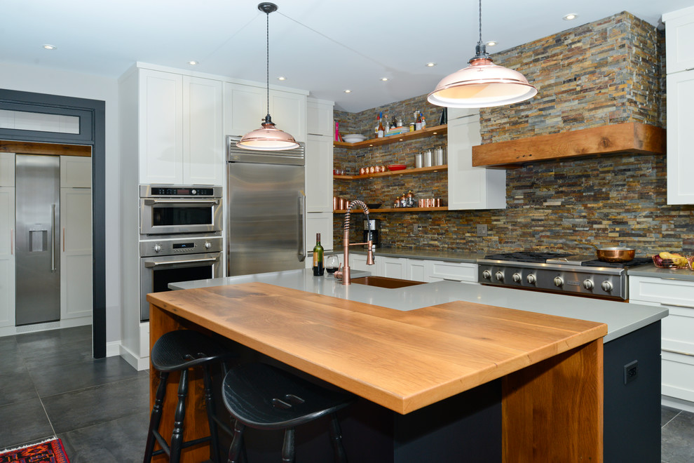 Example of a mid-sized eclectic l-shaped porcelain tile and gray floor open concept kitchen design in DC Metro with a farmhouse sink, shaker cabinets, white cabinets, multicolored backsplash, stone tile backsplash, stainless steel appliances, an island and wood countertops