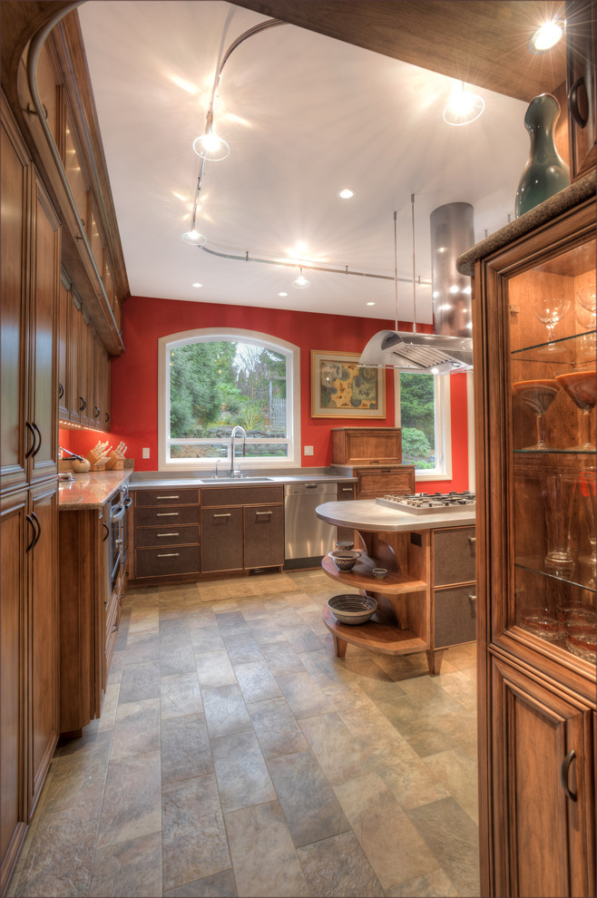 Exempel på ett stort eklektiskt kök, med en nedsänkt diskho, luckor med infälld panel, skåp i mörkt trä, granitbänkskiva, rött stänkskydd, rostfria vitvaror, travertin golv och en köksö