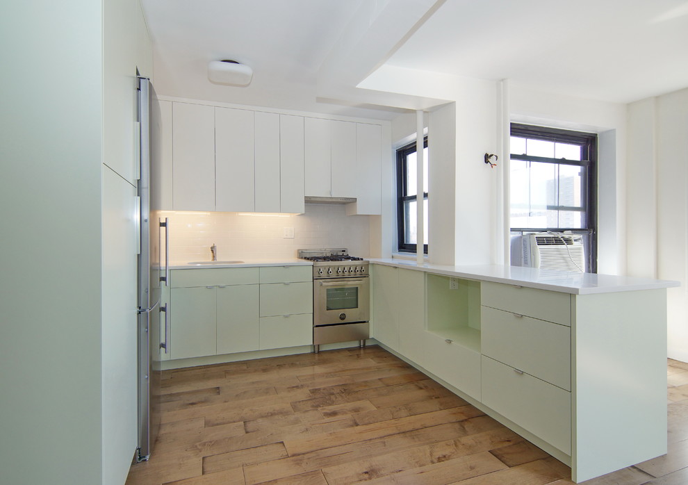 ニューヨークにある高級な小さなコンテンポラリースタイルのおしゃれなキッチン (シングルシンク、フラットパネル扉のキャビネット、緑のキャビネット、クオーツストーンカウンター、白いキッチンパネル、セラミックタイルのキッチンパネル、シルバーの調理設備、無垢フローリング、アイランドなし) の写真