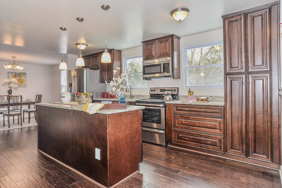Photo of a medium sized classic single-wall kitchen/diner in Louisville with a single-bowl sink, raised-panel cabinets, dark wood cabinets, granite worktops, stainless steel appliances, dark hardwood flooring and an island.