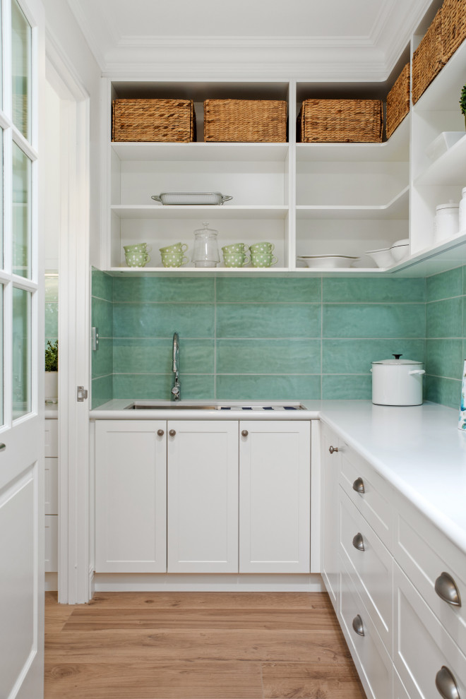 This is an example of a medium sized classic l-shaped kitchen pantry in Perth with a submerged sink, shaker cabinets, white cabinets, green splashback, stainless steel appliances, medium hardwood flooring, no island, brown floors and white worktops.