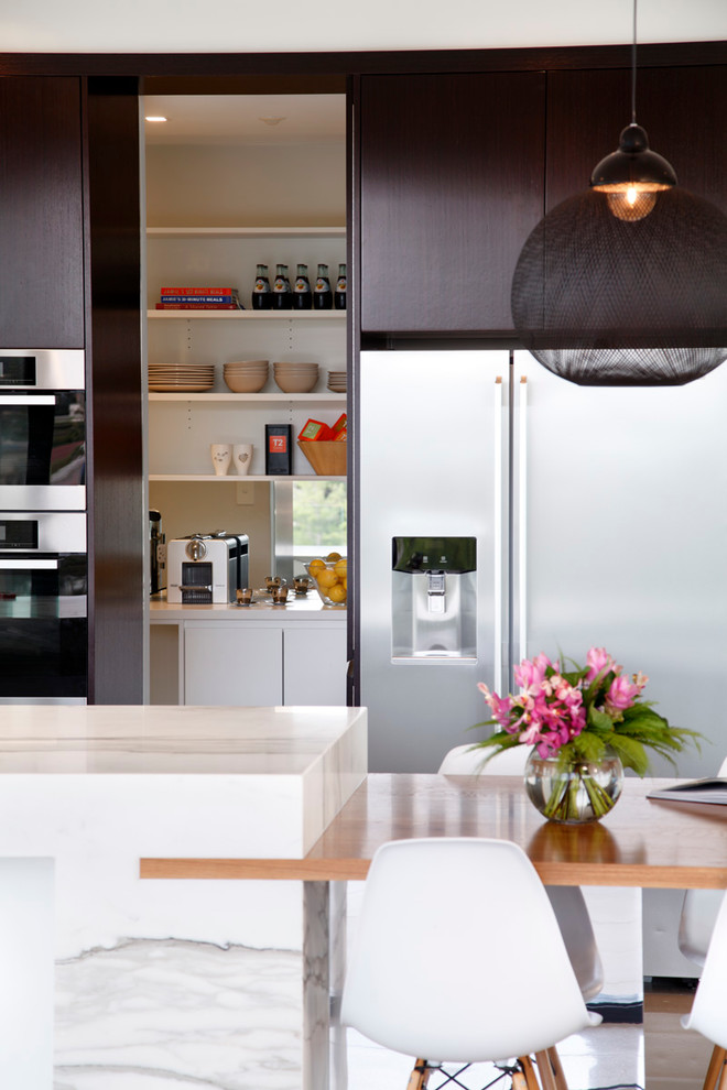 Idee per una cucina moderna chiusa e di medie dimensioni con lavello sottopiano, ante lisce, ante nere, top in marmo, elettrodomestici in acciaio inossidabile e pavimento in gres porcellanato