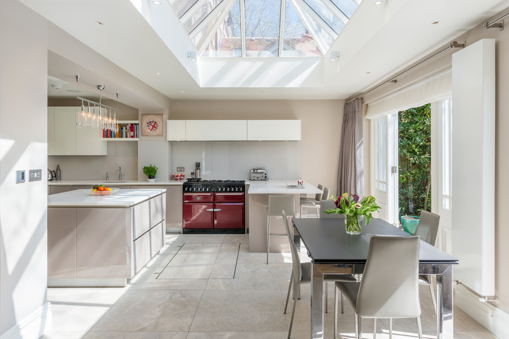 Einzeilige Moderne Wohnküche mit flächenbündigen Schrankfronten, grauen Schränken, bunten Elektrogeräten, Kücheninsel und weißem Boden in Sonstige