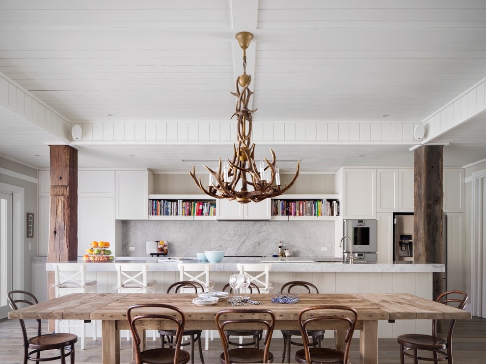 Mid-sized beach style galley eat-in kitchen photo in Sydney with recessed-panel cabinets, white cabinets, marble countertops, stone slab backsplash, stainless steel appliances, an island and white backsplash