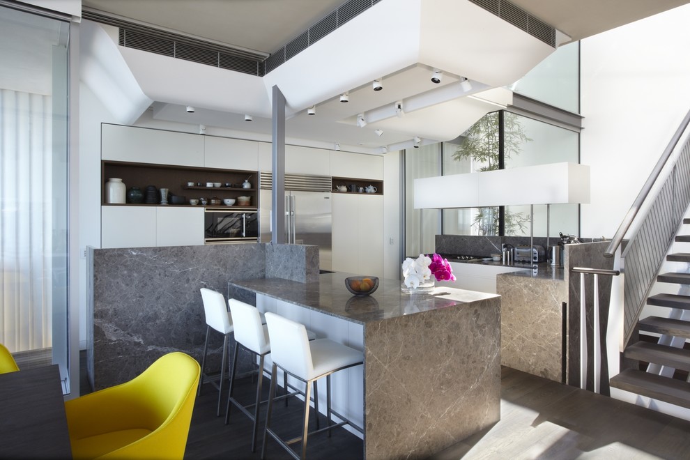 Contemporary l-shaped kitchen/diner in Sydney with flat-panel cabinets, white cabinets, stainless steel appliances, dark hardwood flooring and an island.