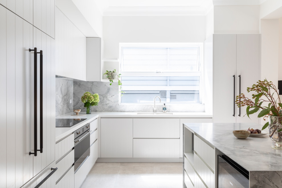 Modern inredning av ett mellanstort grå grått kök, med en undermonterad diskho, vita skåp, marmorbänkskiva, grått stänkskydd, stänkskydd i marmor, rostfria vitvaror, klinkergolv i keramik, en köksö och beiget golv
