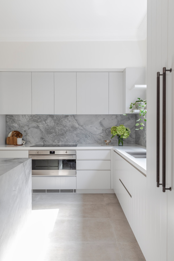 Exempel på ett mellanstort modernt grå grått kök, med en undermonterad diskho, vita skåp, marmorbänkskiva, grått stänkskydd, stänkskydd i marmor, rostfria vitvaror, klinkergolv i keramik, en köksö och beiget golv