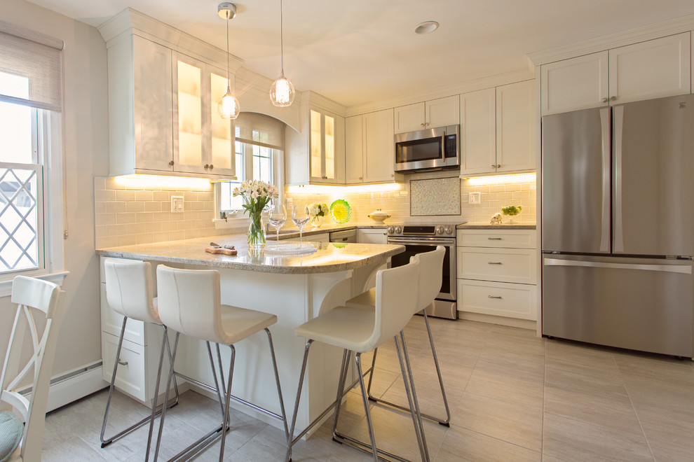Inspiration for a mid-sized contemporary u-shaped travertine floor eat-in kitchen remodel in Bridgeport with an undermount sink, shaker cabinets, white cabinets, granite countertops, beige backsplash, ceramic backsplash, stainless steel appliances and a peninsula