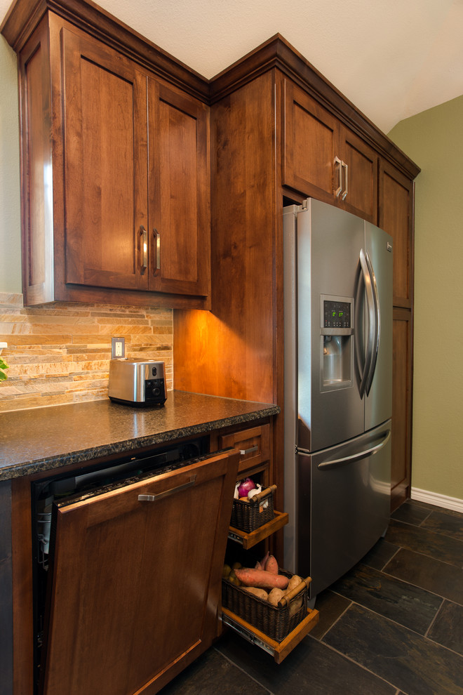 Expansive farmhouse u-shaped kitchen/diner in Dallas with a belfast sink, shaker cabinets, medium wood cabinets, granite worktops, beige splashback, stone tiled splashback, stainless steel appliances, slate flooring and an island.