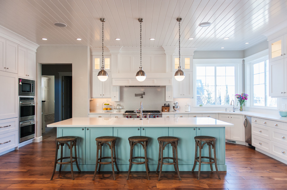 Example of a large transitional u-shaped medium tone wood floor and brown floor eat-in kitchen design in Salt Lake City with white backsplash, stainless steel appliances, an undermount sink, shaker cabinets, white cabinets, quartz countertops and an island