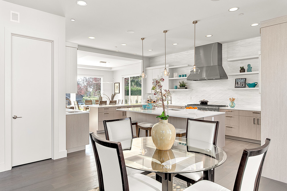 Example of a large trendy single-wall medium tone wood floor and gray floor eat-in kitchen design in Seattle with an undermount sink, flat-panel cabinets, light wood cabinets, solid surface countertops, white backsplash, porcelain backsplash, stainless steel appliances and an island