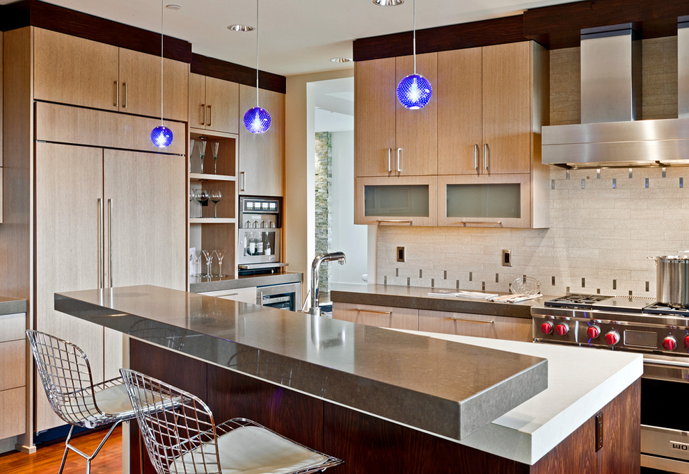 Foto di una grande cucina design con ante lisce, ante in legno chiaro, paraspruzzi beige e elettrodomestici in acciaio inossidabile