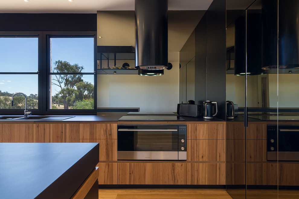 Moderne Wohnküche mit Lamellenschränken und Kücheninsel in Melbourne