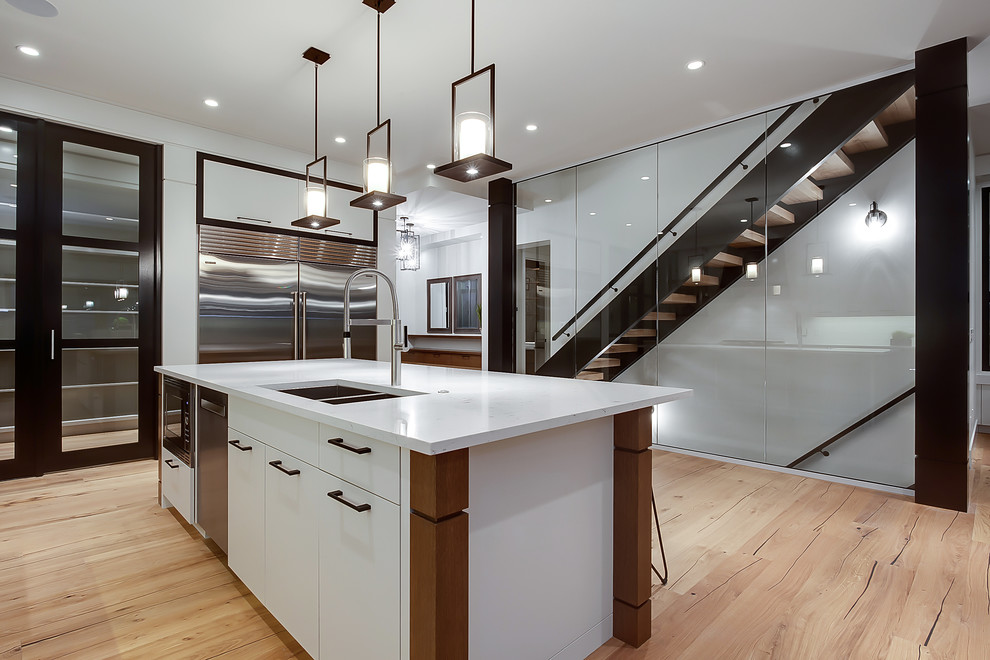 Klassische Küche mit Rückwand aus Metrofliesen und hellem Holzboden in Calgary