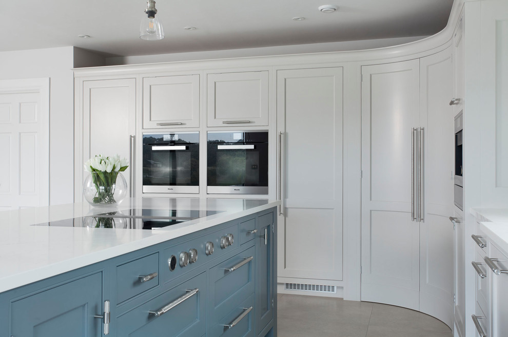 Cette photo montre une grande cuisine ouverte tendance en L avec un placard à porte shaker, des portes de placard grises, un plan de travail en quartz, îlot et un plan de travail blanc.