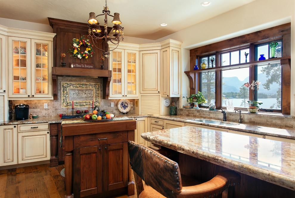 Foto de cocina clásica con fregadero bajoencimera, armarios con paneles con relieve, puertas de armario beige, encimera de granito y salpicadero de azulejos de piedra