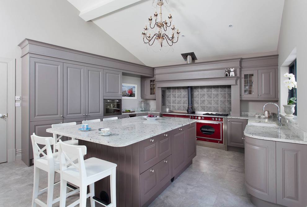 Inspiration for a mid-sized transitional u-shaped ceramic tile enclosed kitchen remodel in Other with a farmhouse sink, raised-panel cabinets, gray cabinets, granite countertops, white backsplash, stone slab backsplash, stainless steel appliances and an island