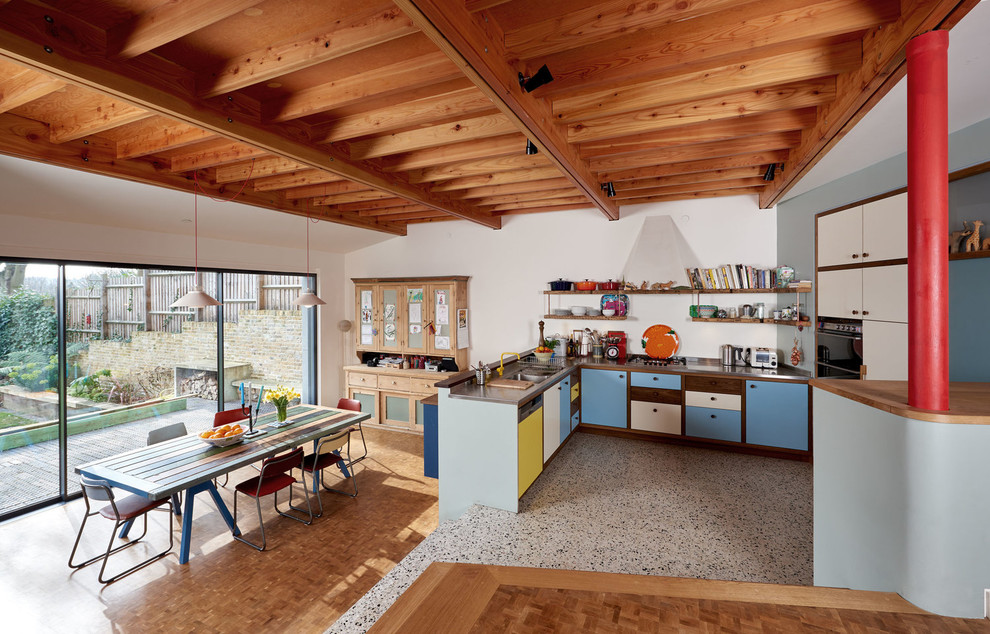 Идея дизайна: п-образная кухня-гостиная среднего размера в стиле ретро с двойной мойкой, плоскими фасадами, техникой из нержавеющей стали, паркетным полом среднего тона и коричневым полом