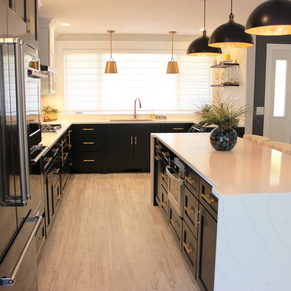Inspiration for a large transitional l-shaped vinyl floor and gray floor open concept kitchen remodel in Other with an undermount sink, flat-panel cabinets, black cabinets, quartz countertops, white backsplash, marble backsplash, black appliances and an island