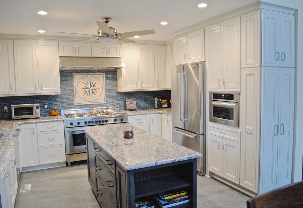 Mid-sized beach style u-shaped porcelain tile kitchen pantry photo in DC Metro with an undermount sink, flat-panel cabinets, white cabinets, granite countertops, blue backsplash, glass tile backsplash, stainless steel appliances and an island