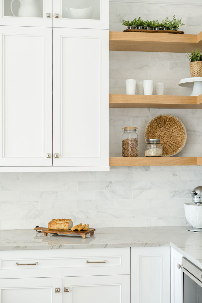 Foto de cocina marinera con armarios estilo shaker, puertas de armario blancas, salpicadero de mármol, una isla y encimeras blancas