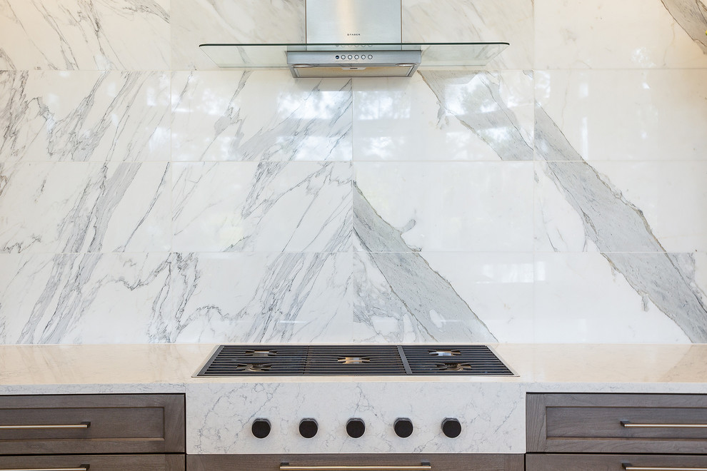 Immagine di una cucina ad ambiente unico design con ante lisce, top in marmo e paraspruzzi in marmo