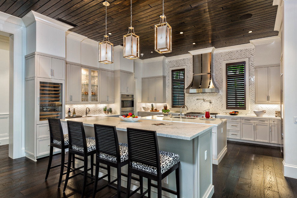 Klassische Küche in U-Form mit Marmor-Arbeitsplatte, Rückwand aus Mosaikfliesen, dunklem Holzboden, zwei Kücheninseln, Schrankfronten im Shaker-Stil, grauen Schränken, Küchenrückwand in Grau und Küchengeräten aus Edelstahl in Miami