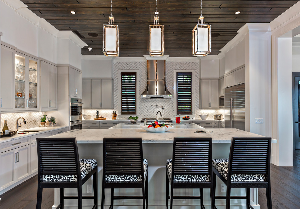 Klassische Küche mit Marmor-Arbeitsplatte, Rückwand aus Mosaikfliesen, dunklem Holzboden und zwei Kücheninseln in Miami