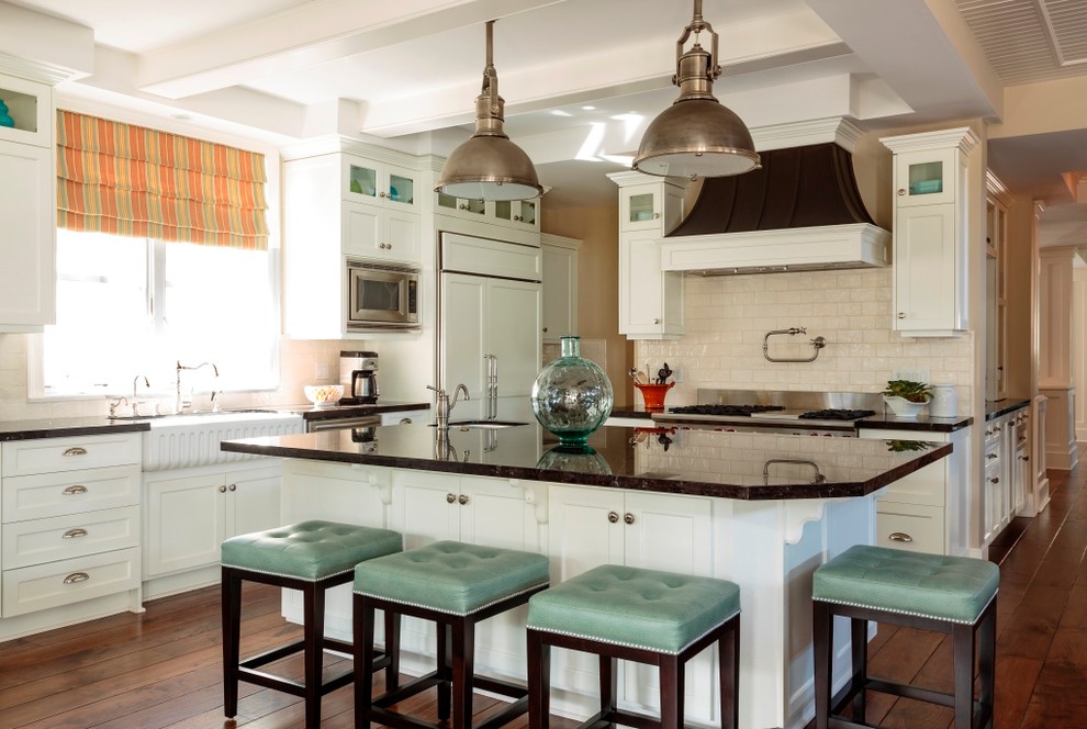 Example of a beach style kitchen design in Los Angeles with a farmhouse sink, shaker cabinets, white cabinets, beige backsplash, subway tile backsplash and paneled appliances