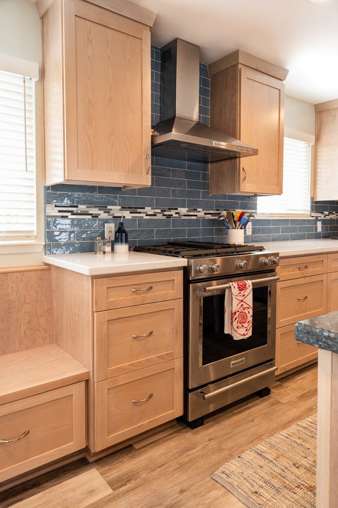Exempel på ett mellanstort maritimt flerfärgad flerfärgat kök, med en nedsänkt diskho, skåp i shakerstil, skåp i ljust trä, bänkskiva i kvarts, blått stänkskydd, stänkskydd i keramik, rostfria vitvaror, laminatgolv, en köksö och beiget golv