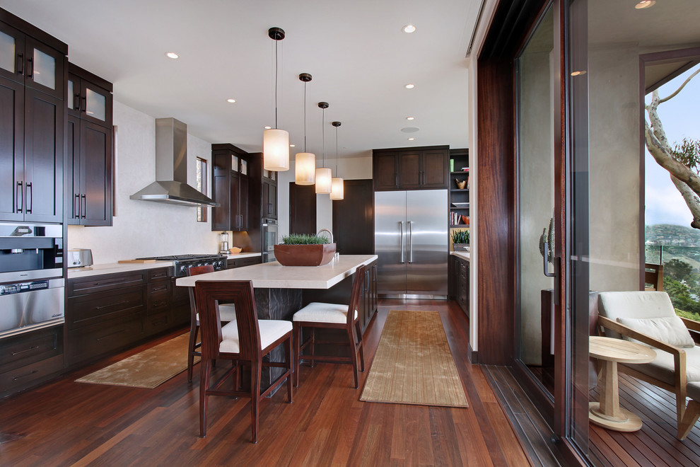 Example of a trendy kitchen design in Orange County with shaker cabinets, dark wood cabinets and stainless steel appliances