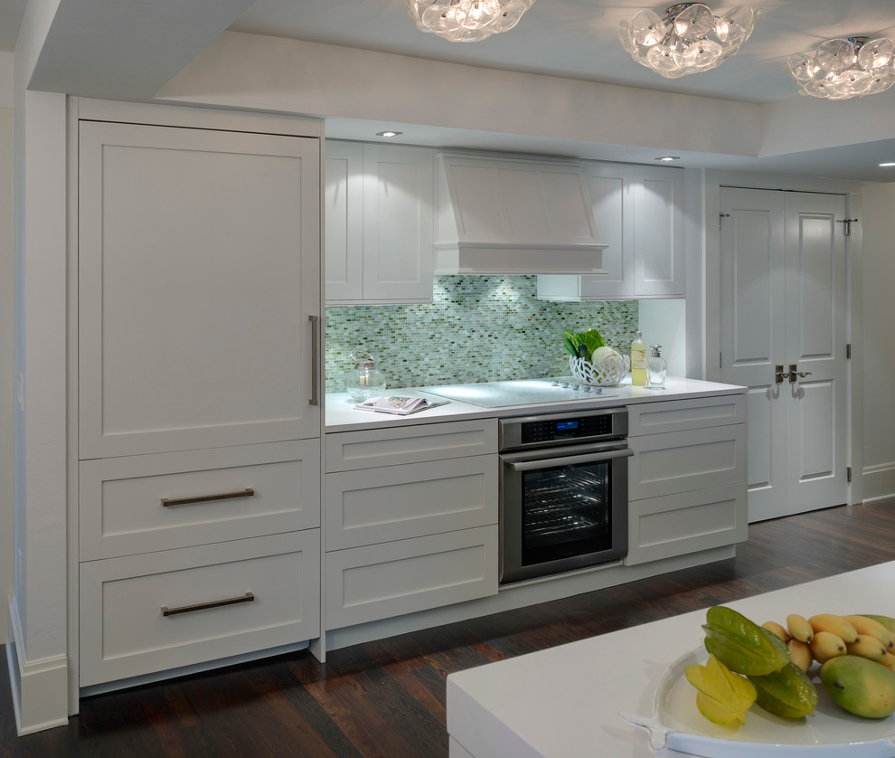 Beach style galley open concept kitchen photo in Miami with shaker cabinets, white cabinets, quartz countertops, blue backsplash and paneled appliances