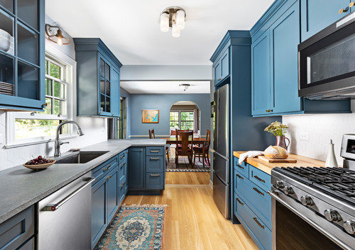 Modern kitchen with bold blue shaker cabinets, stainless steel appliances, and wood countertops – stylish Kitchen & Bathroom Cabinets design